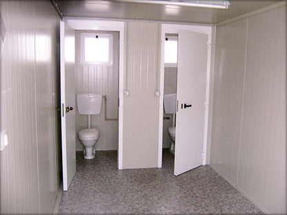 Cabine sanitaire avec toilettes séparées et douche indépendante
